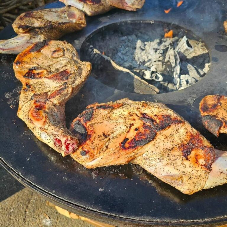 Pièces de viande rôties autour du foyer de braises d'un braséro rond de 80