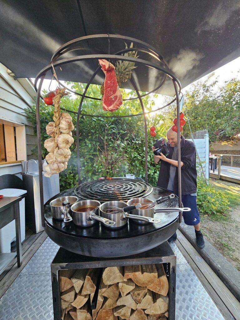 Braséro rond de 100 avec cage, sur meuble à bûches, terrasse de montagne