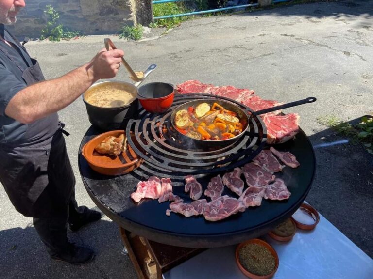 Cuisinier derrière un braséro garni d'une poêle, de ramequins et de pièces de viande crues