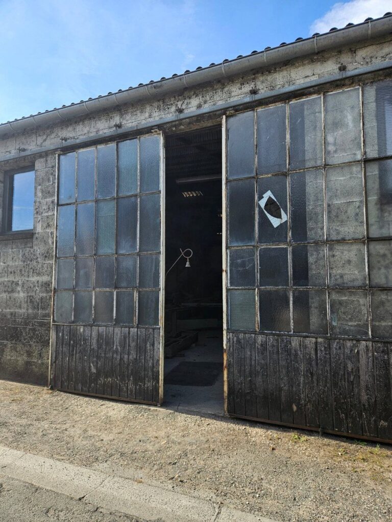 Façade du hangar de l'atelier du tonnelier, près de Cognac, portes vitrées entrouvertes
