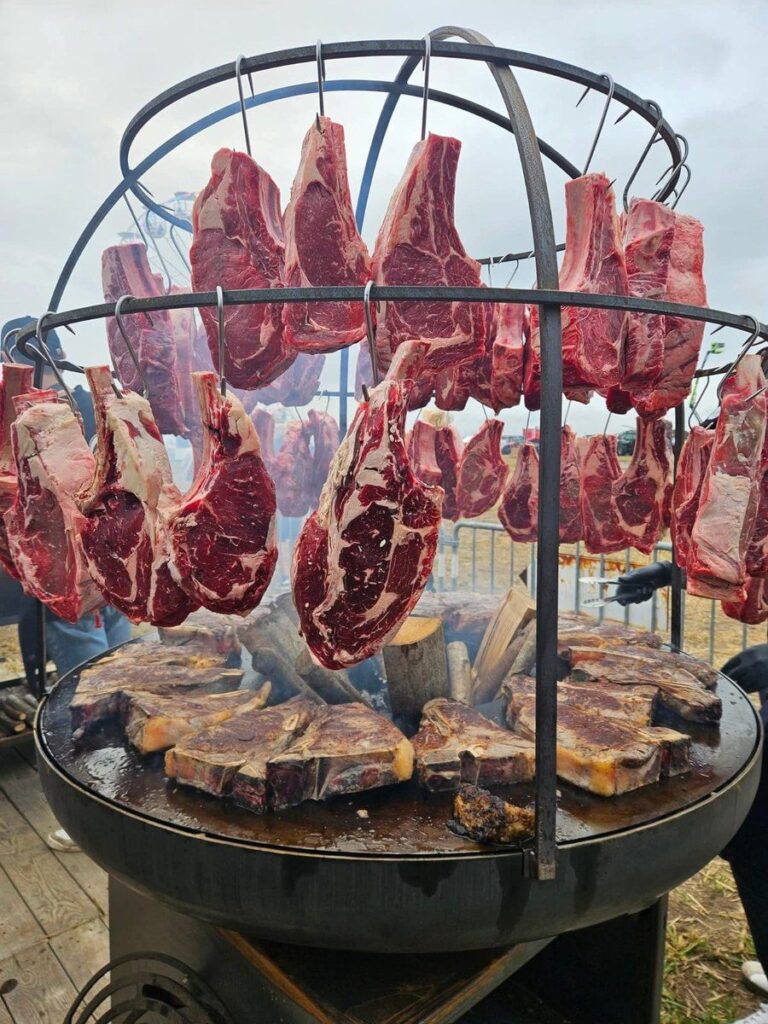 Cage pour braséro et côtes de bœuf suspendues au-dessus de la plancha