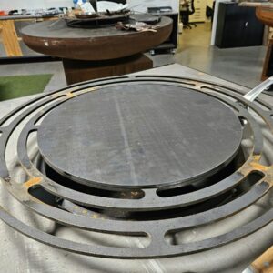 Crêpière simple en acier posée sur la grille d'un braséro