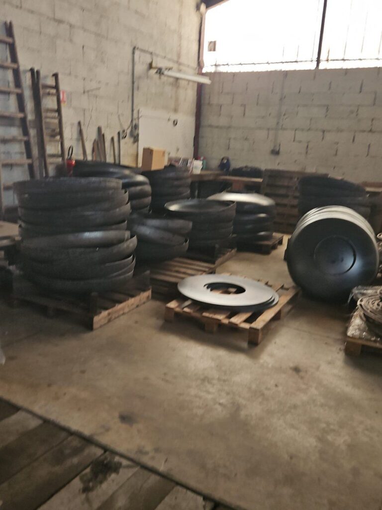 Calottes et plateaux en acier brut stockés à l'atelier