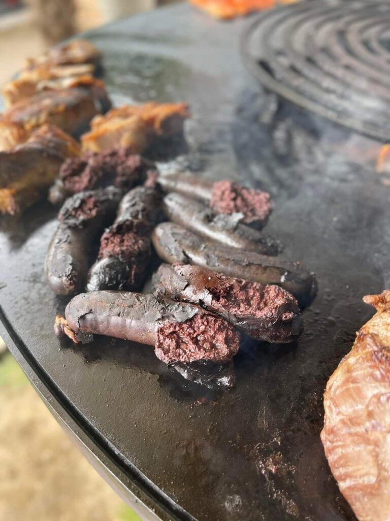 Boudins noirs grillés sur la plancha, grille ronde au fond