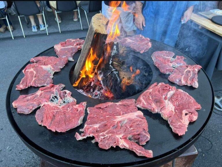 Braséro garni de côtes de bœuf crues autour d'une bûche enflammée