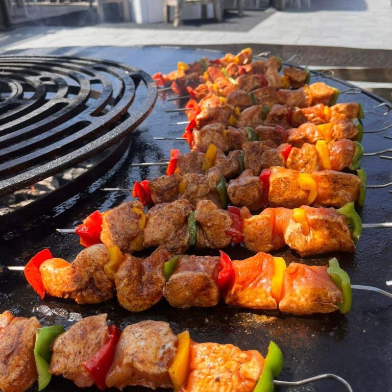 Brochettes de poulet et de poivrons alignées sur la plancha