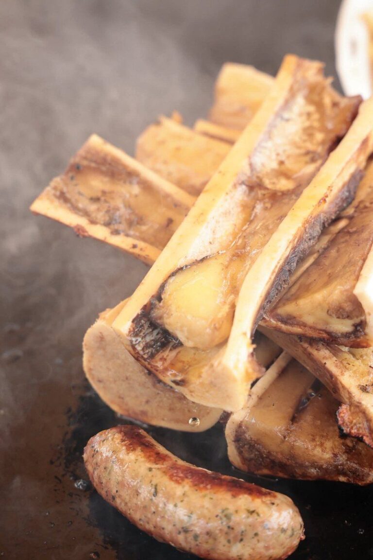 Os à moelle et saucisse grillés en gros plan sur la plancha