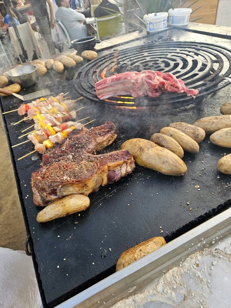 Plancha en bord de mer : côte de bœuf, pommes de terre et brochettes au coucher du soleil