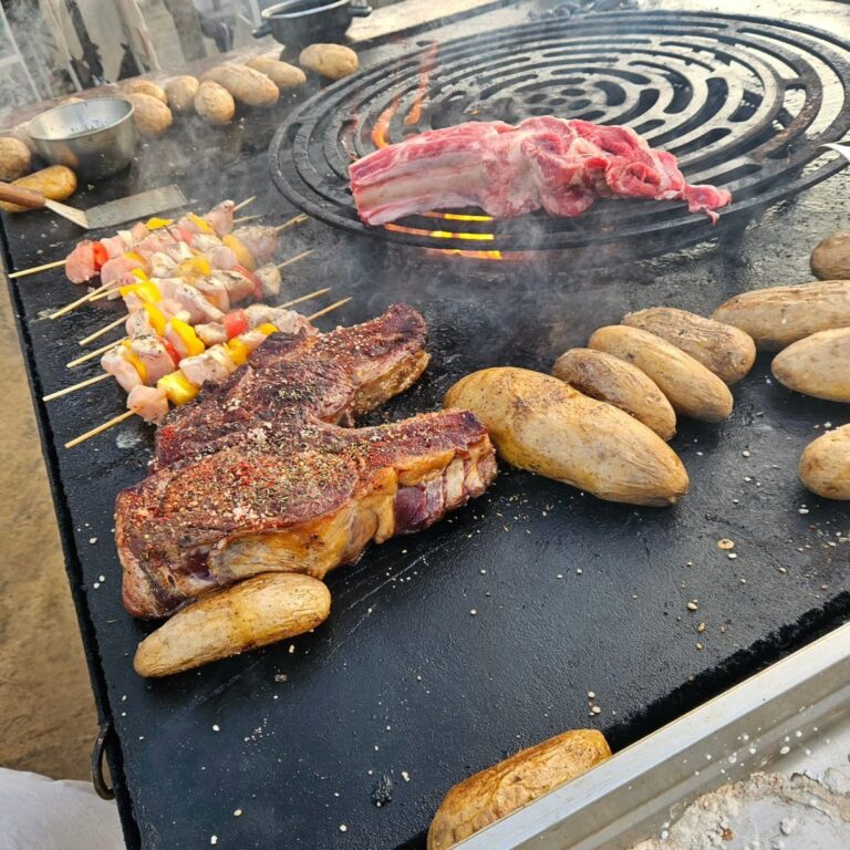 Côte de bœuf, pommes de terre et brochettes sur la plancha, mer en arrière-plan