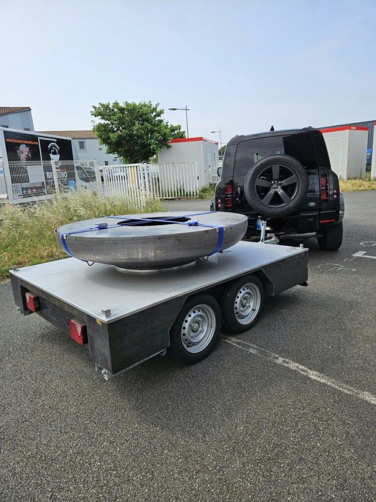 Remorque à double essieu portant un braséro sanglé, 4x4 garé derrière