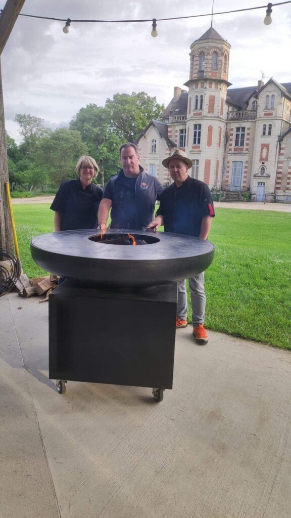 Trois cuisiniers devant un braséro rond, château en arrière-plan