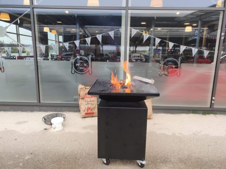 Braséro carré de 80 sur meuble noir à roulettes, flammes dans le foyer